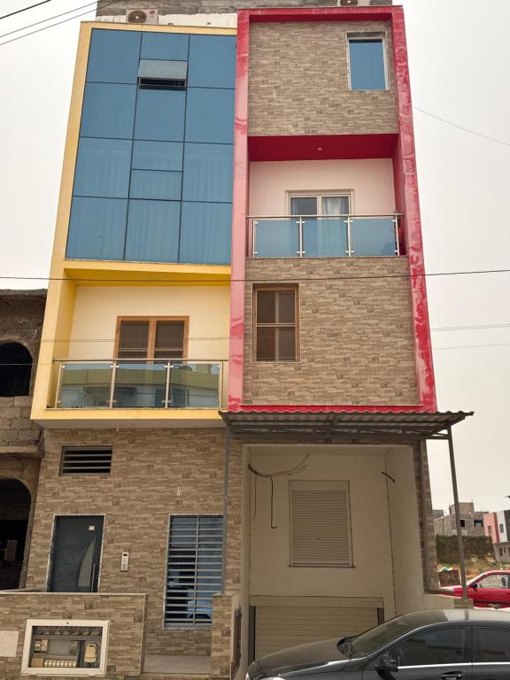 a tall building with a car parked in front of it at Ap Emanuel in Praia
