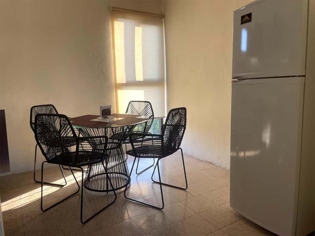 a dining room with a table and chairs and a refrigerator at Depa Pakabtun 2 hab wifi in Mérida