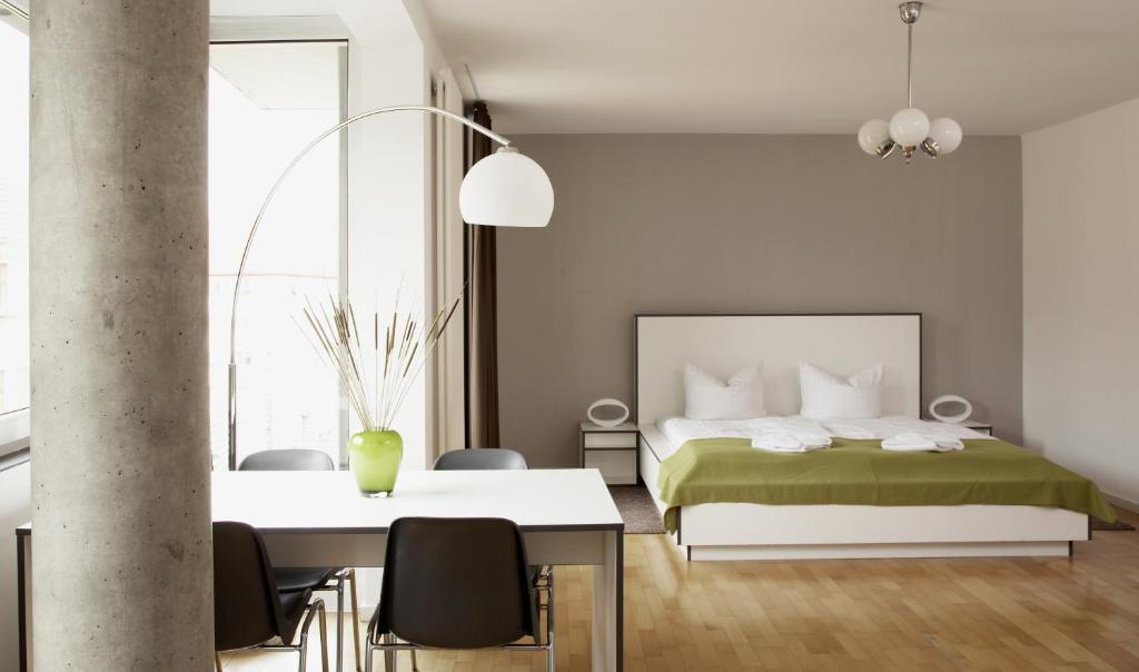 um quarto com uma cama, uma mesa e cadeiras em Karlito Apartmenthaus em Berlim