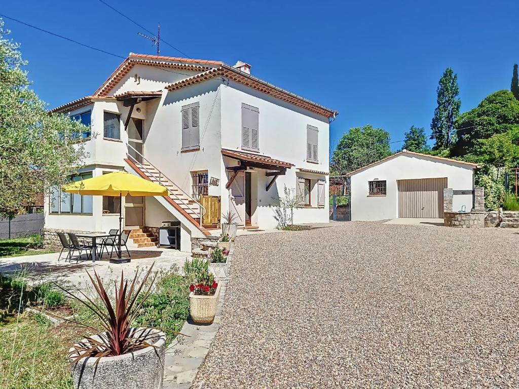 a white house with a table and a patio at Rez de villa de charme à Montauroux près du lac Saint-Cassien, 2 chambres, jardin privatif - FR-1-779-16 in Montauroux