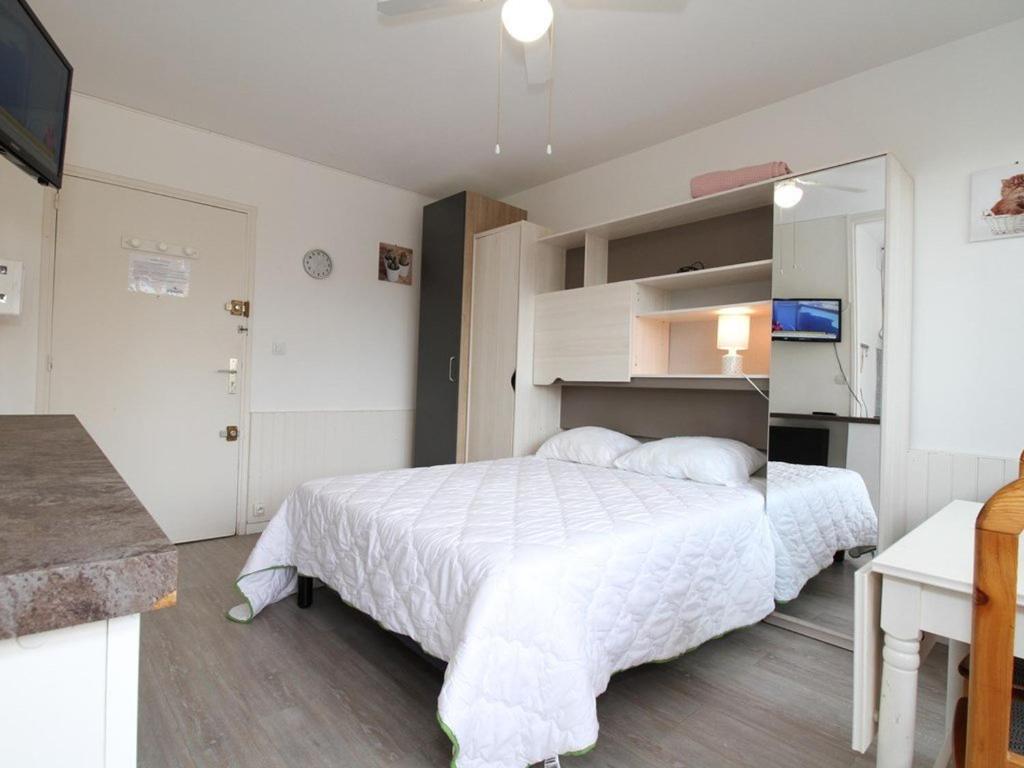 une chambre avec un lit blanc et une télévision dans l'établissement Studio rénové à Balaruc-les-Bains, proche Thermes - FR-1-553-304, à Balaruc-les-Bains