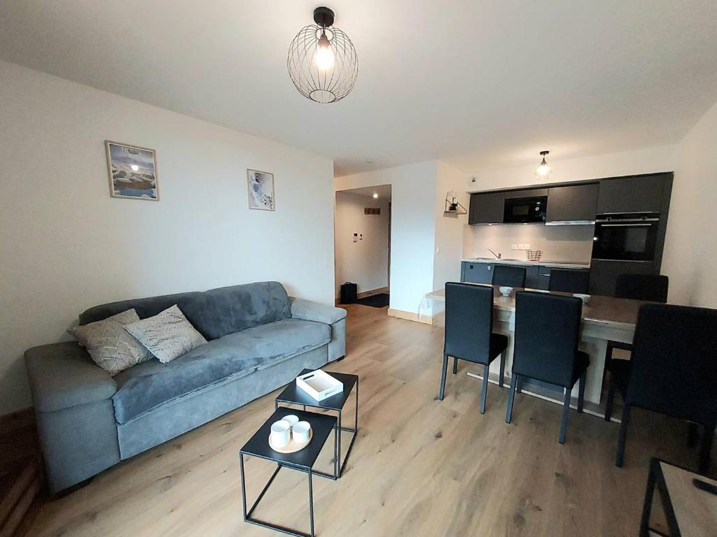 un salon avec un canapé et une table avec des chaises dans l'établissement Appartement cosy 6 pers, accès pistes, parking inclus - FR-1-356-536, à Valmorel