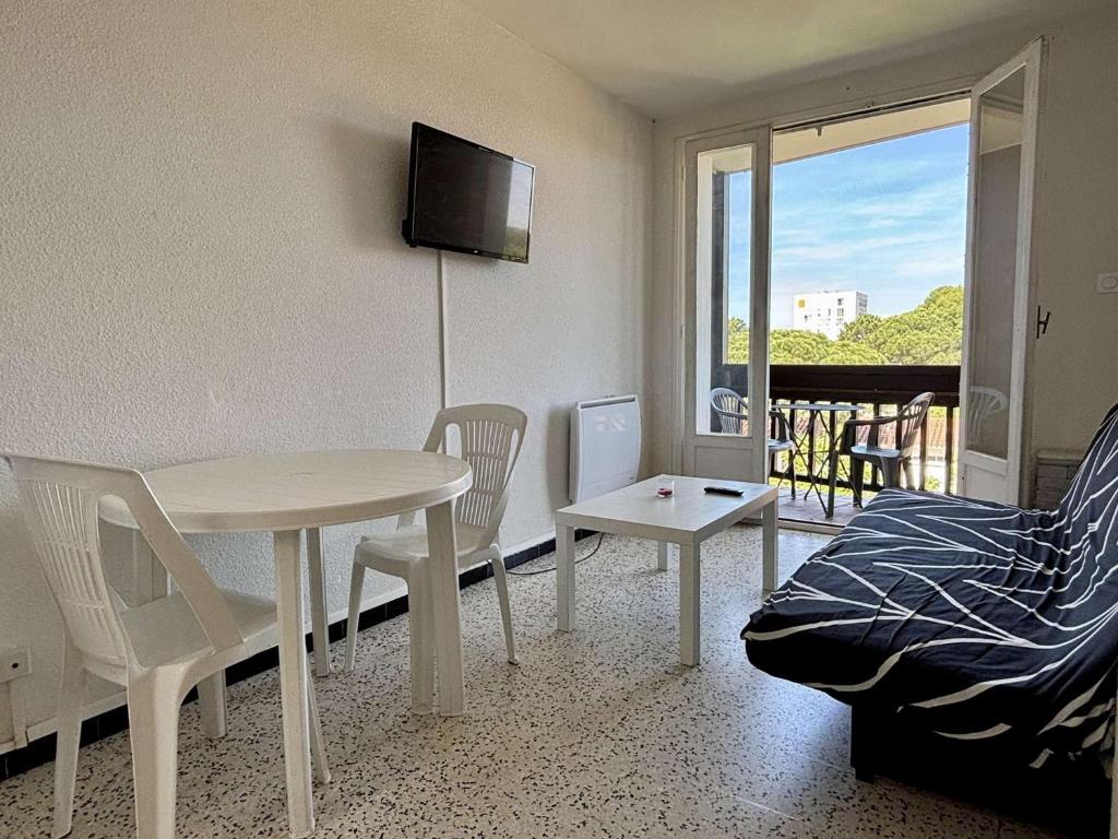 un salon avec une table et des chaises et un balcon dans l'établissement Appartement 2 pièces à 100m de la mer, Argelès-sur-Mer - FR-1-225-833, à Argelès-sur-Mer