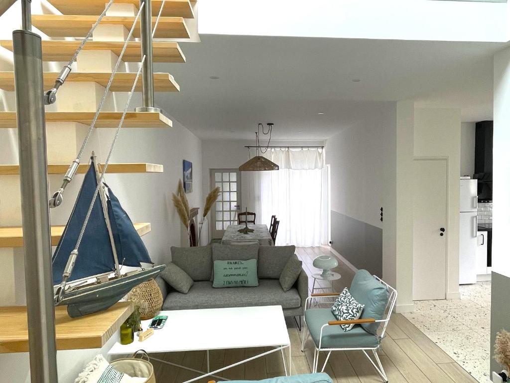 - un salon avec un canapé et un bateau sur le mur dans l'établissement Maison charmante proche plage et commerces avec WIFI - FR-1-652-60, à Saint-Jean-de-Monts