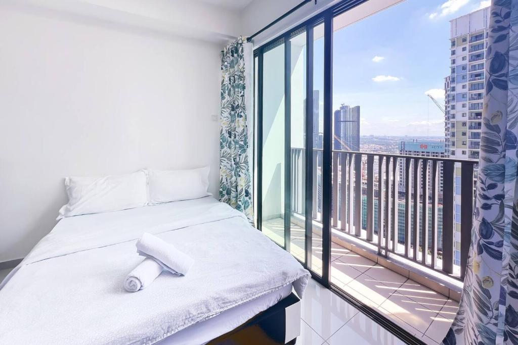 a room with a bed and a balcony with a view at I-City Luxury Condominiums, Shah Alam by Smarthome in Shah Alam