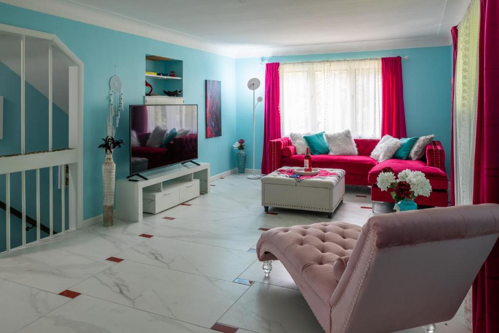 - un salon avec un canapé rose et une télévision dans l'établissement Little Paris- In Affluent University HTS, à University Heights