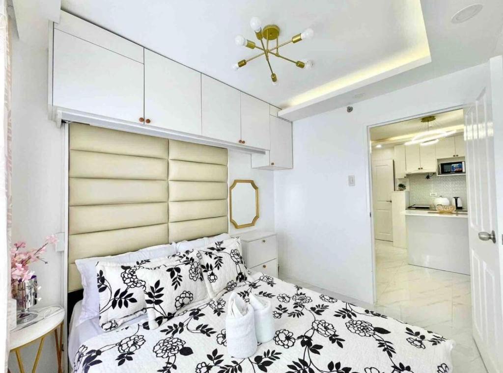 达沃市2BR Condo with Free Pool Access and Wifi的卧室里有一张床，配有黑白枕头