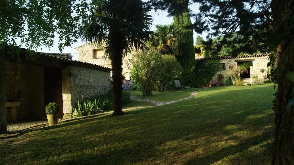 a green yard with a house and a tree at Chambres d'hôtes La Chabrière in Cliousclat