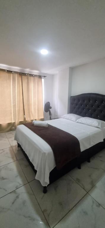 a bedroom with a large bed in a room at Apartahotel Rubí San Gil in San Gil