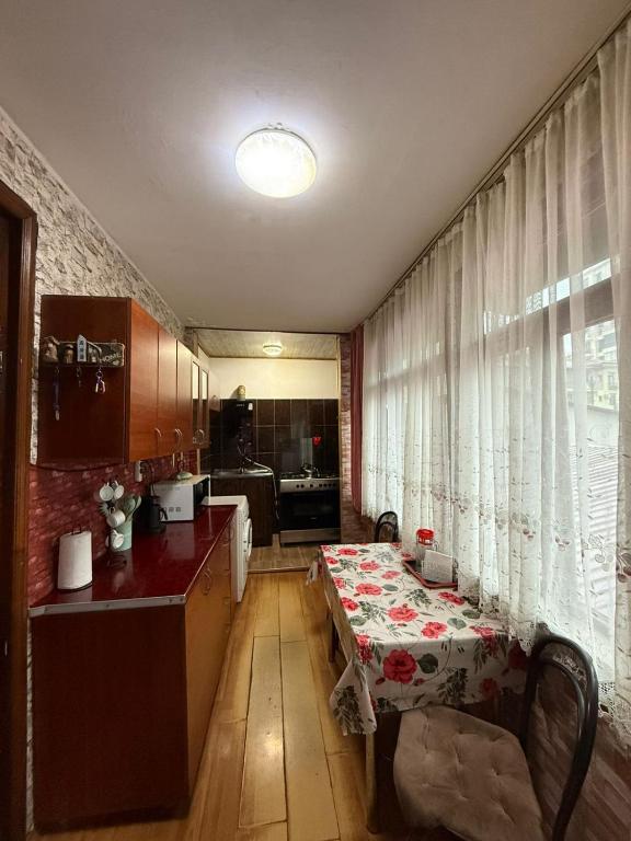 a kitchen with a table with a flowered table cloth at Квартира у бульвара 1 in Batumi
