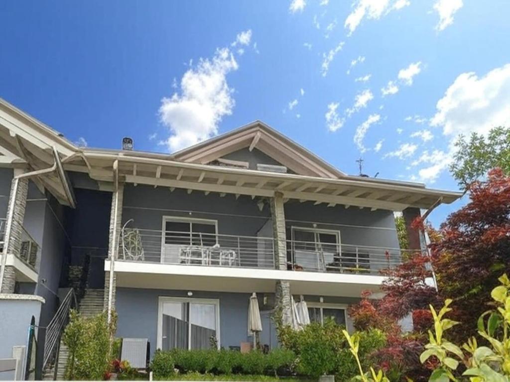 a large house with a balcony and blue sky at Apartment near Lake Maggiore in Meina