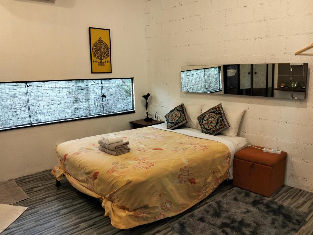 Un dormitorio con una cama grande en una habitación con ventanas. en Baba pim villa, en Chiang Mai