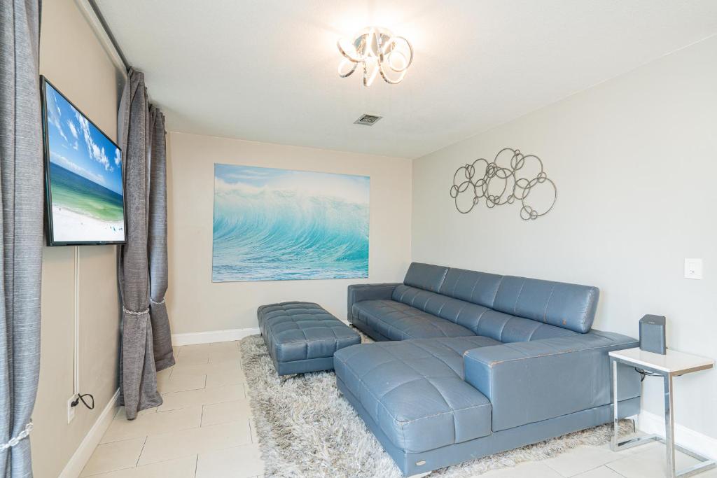 a living room with a blue couch and a flat screen tv at Long Island at Laguna Point in Destin