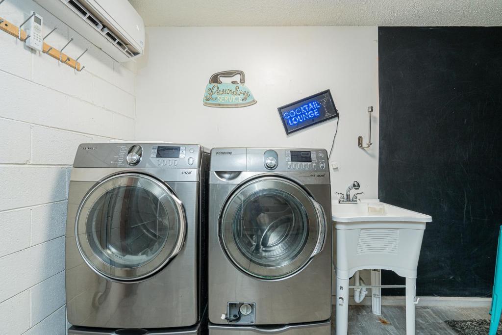 a laundry room with two washing machines and a sink at Long Island at Laguna Point in Destin
