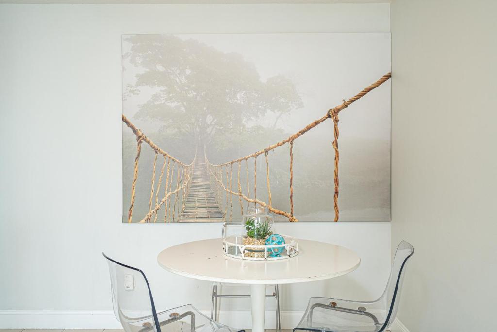 a table with chairs and a picture of a suspension bridge at Long Island at Laguna Point in Destin