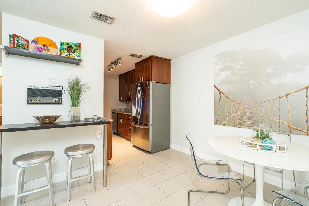 a kitchen with a table and chairs and a bridge painting on the wall at Long Island at Laguna Point in Destin