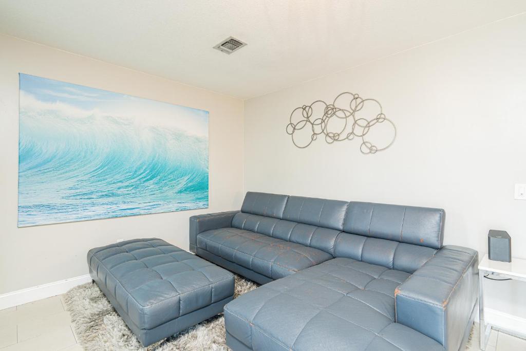 a living room with a blue couch and a painting at Long Island at Laguna Point in Destin