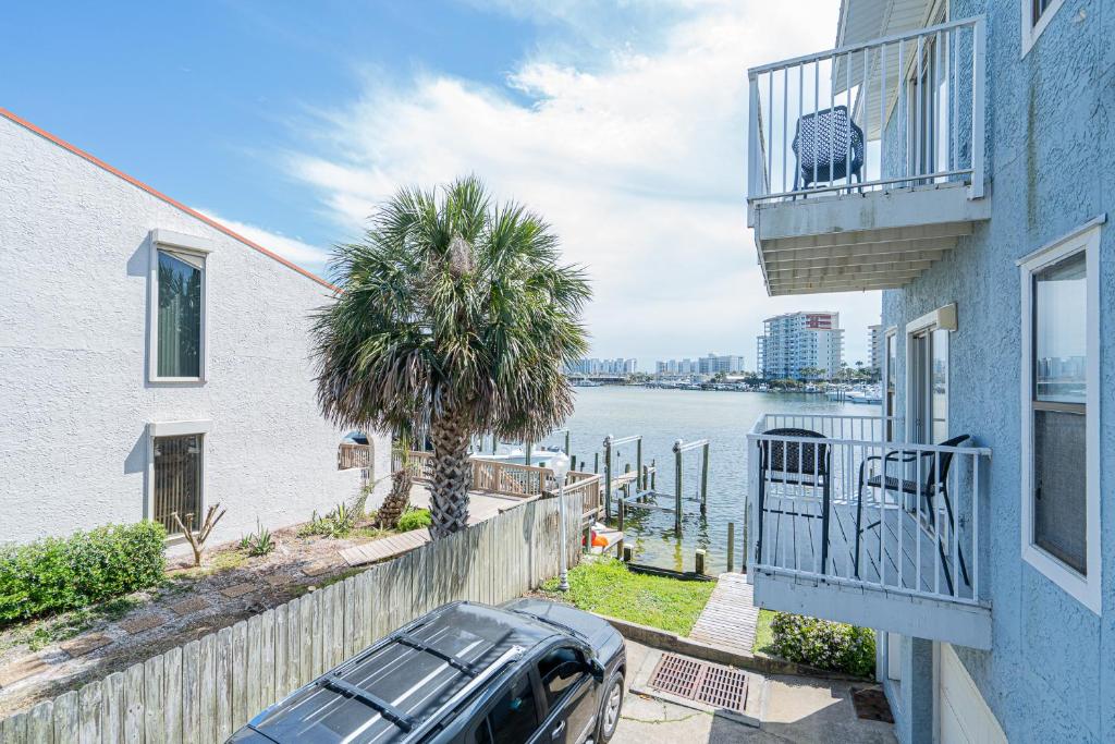 a car parked next to a house with a palm tree at Long Island at Laguna Point in Destin
