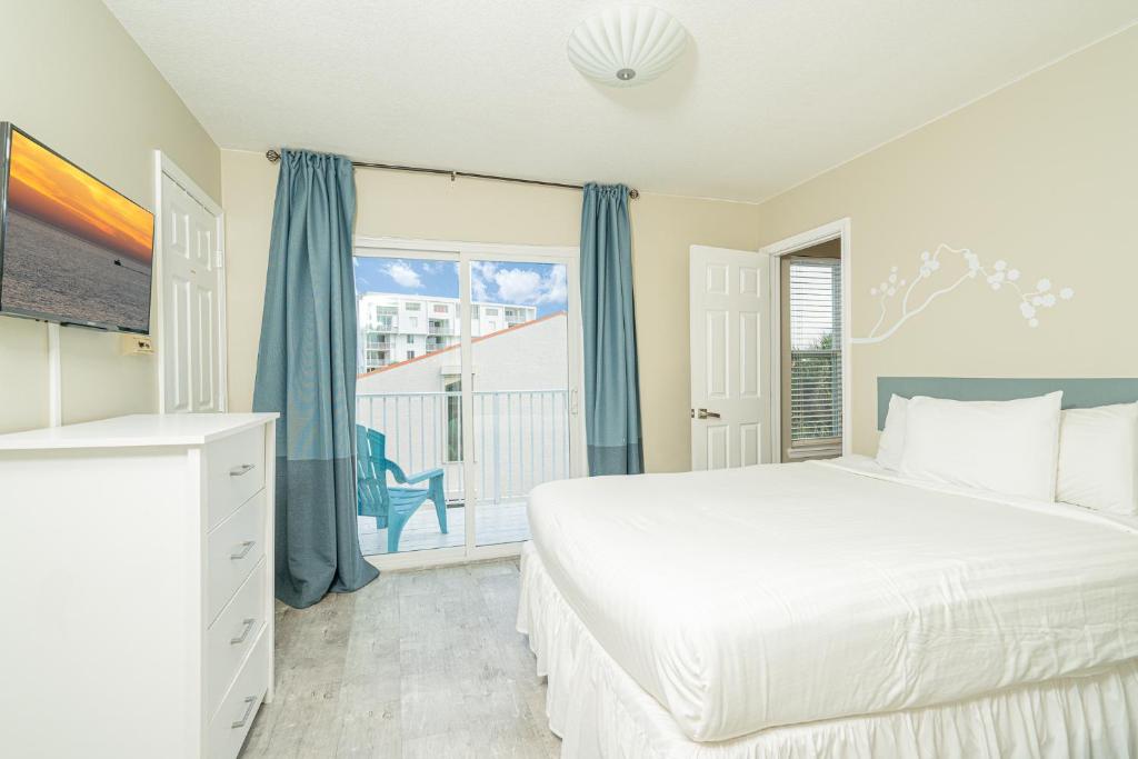 a bedroom with a bed and a balcony at Long Island at Laguna Point in Destin