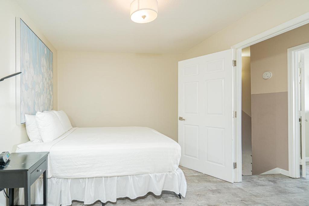 a white bedroom with a bed and a desk at Long Island at Laguna Point in Destin