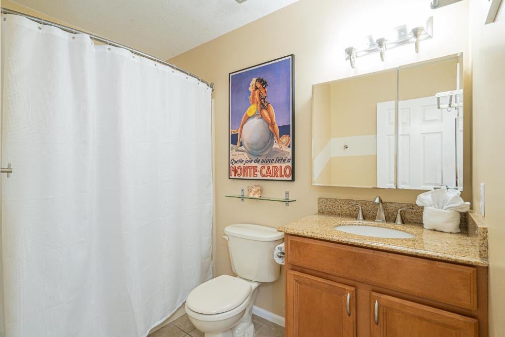 a bathroom with a toilet and a sink and a mirror at Long Island at Laguna Point in Destin