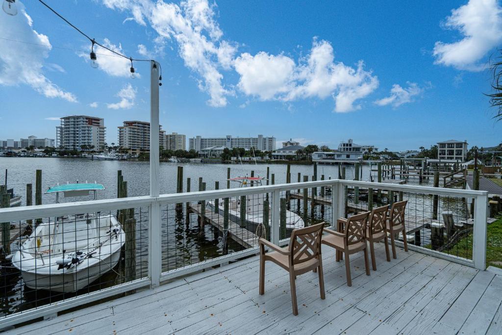 a deck with two chairs and a boat on the water at Long Island at Laguna Point in Destin