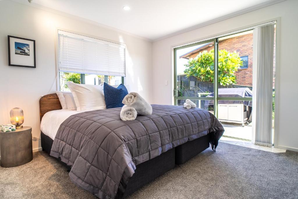 a bedroom with a bed with two stuffed animals on it at Spacious Coastal Retreat, Ideal for Families in Mangawhai