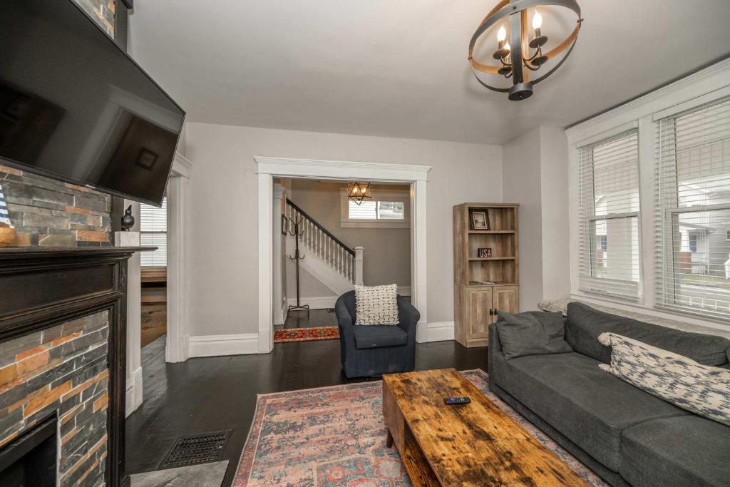 ein Wohnzimmer mit Sofa und Tisch in der Unterkunft The Restful Roost w Hot Tub in Columbus