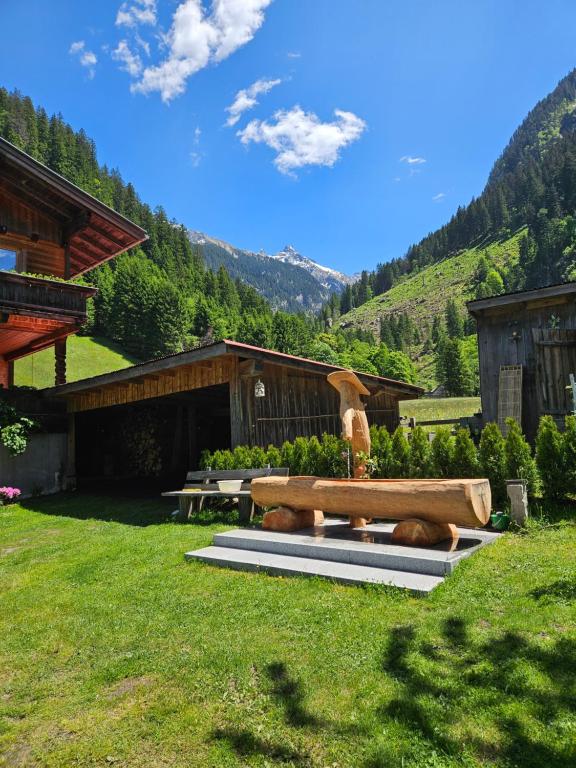 a park bench with a fountain in the grass at Apartment Wandegg im Bergsteigerdorf Ginzling Mayrhofen in Mayrhofen