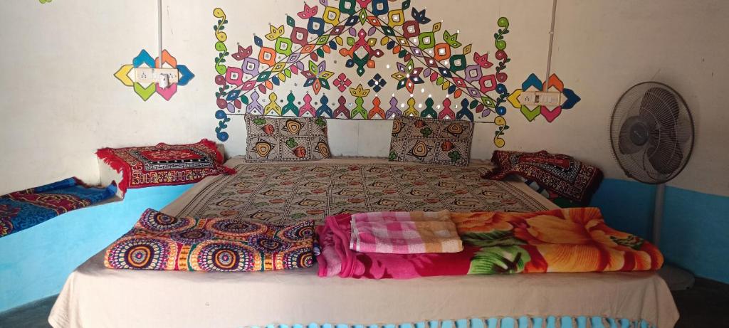 Dormitorio con cama con cabecero colorido en White Desert Home Stay, en Dhordo