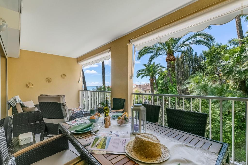 un patio avec une table et des chaises sur un balcon dans l'établissement Saint Laurent Apt Garden View - Happy Rentals, à Menton
