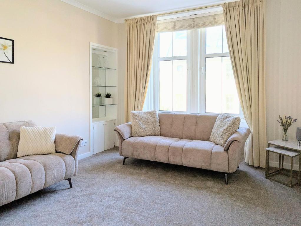 a living room with two couches and a window at Kirk street apartment in Campbeltown