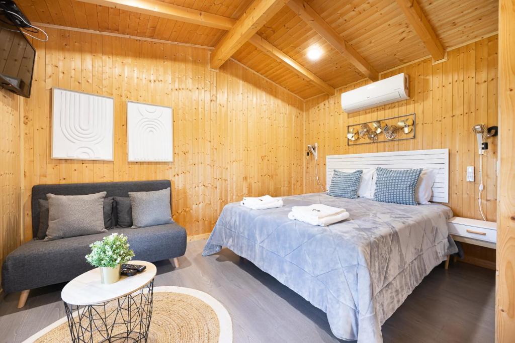 a bedroom with a bed and a couch in a room at Craveira Country House in Sonega