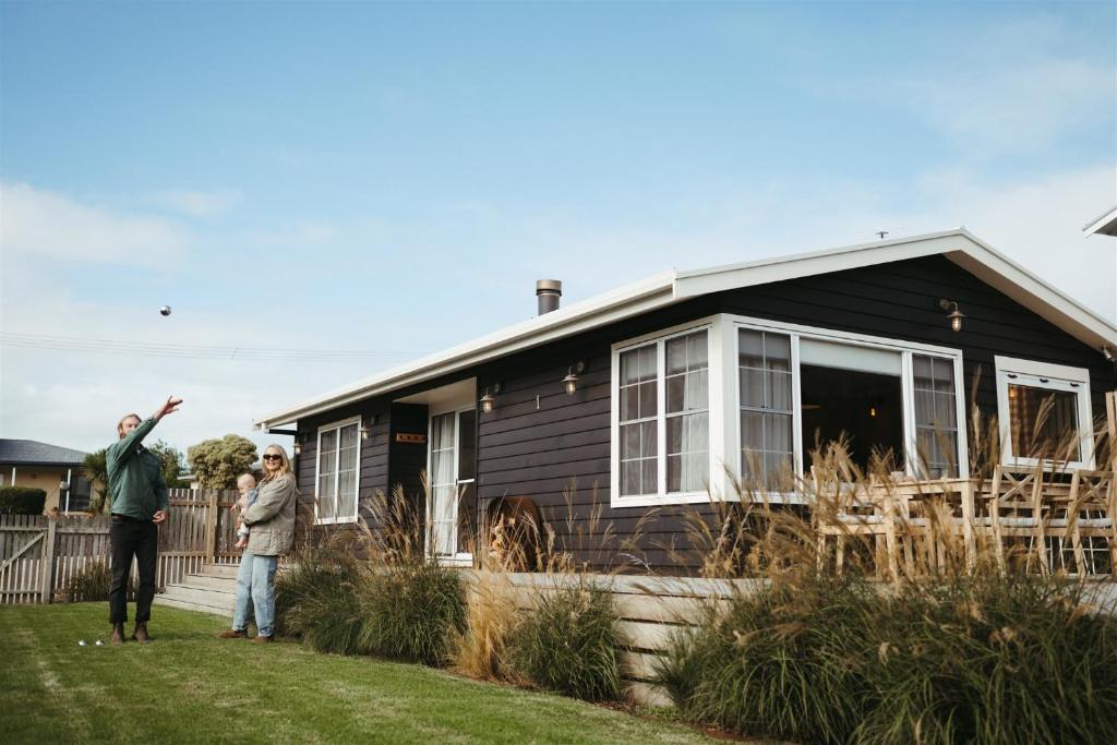 two people standing in front of a small house at The Woodshed - Hot Stone Sauna & Ice Bath in Robe