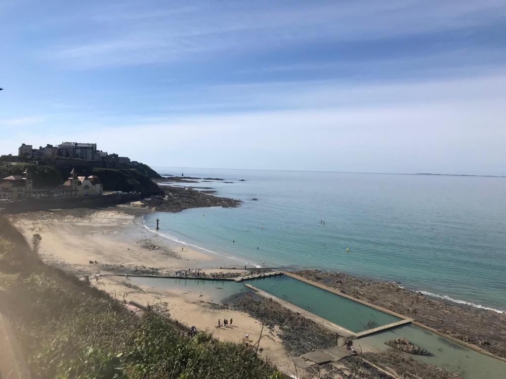 a beach with a swimming pool in the water at Joli appartement à 7 minutes à pied de la plage in Granville