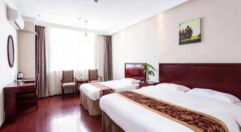 a hotel room with two beds and a desk at GreenTree Inn Shanghai Changxing Island Yuansha Fishing Port Hotel in Yuansha