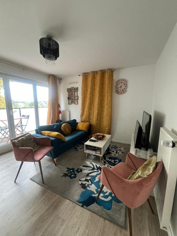 un salon avec un canapé bleu et des chaises dans l'établissement Entire Simple, cozy family apartment, à Thorigny-sur-Marne
