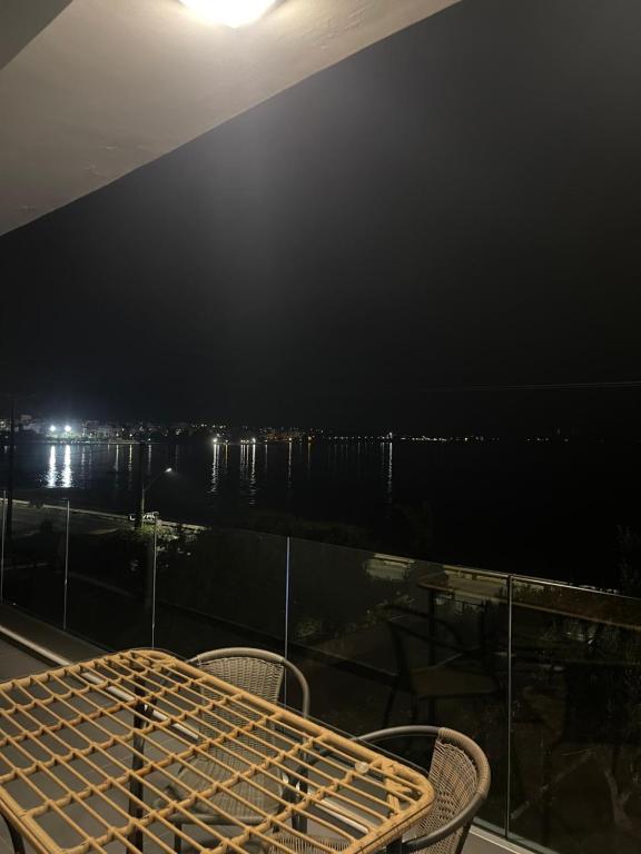 a table and chairs on a balcony at night at Luxury Apartment Sea View Chalkida in Chalkida