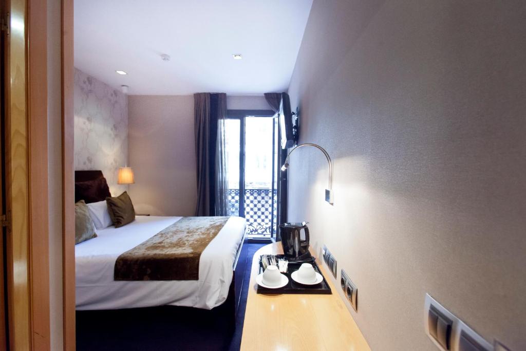 een hotelkamer met een bed en een tafel met een koffiezetapparaat bij Casa Boutique Barcelona in Barcelona