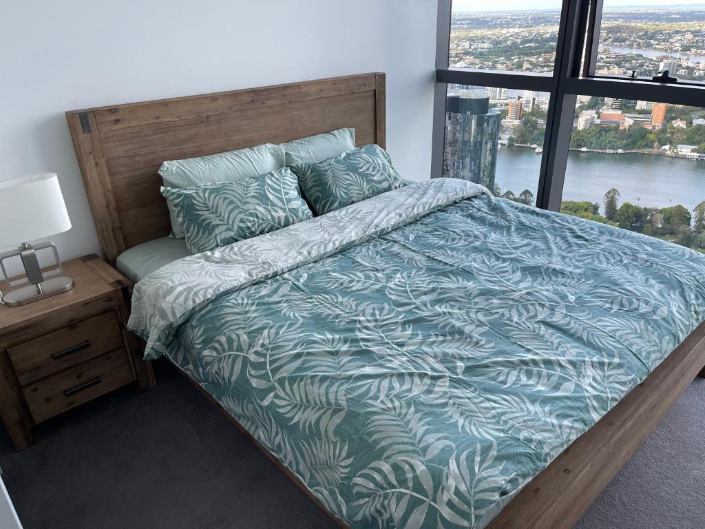 a bedroom with a large bed with a large window at Queens Wharf 50th Floor in Brisbane