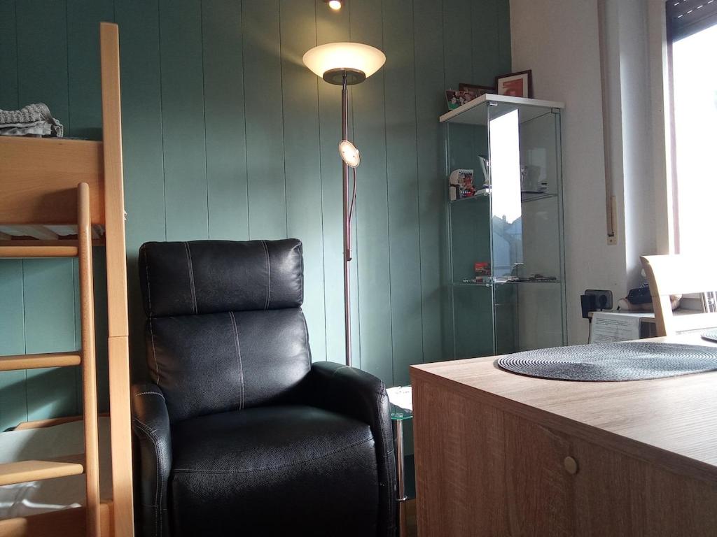 une chaise noire assise à côté d'un bureau avec une lampe dans l'établissement Komplette Wohnung Schwarzwaldpforte Casa BaLi direkte Buchung möglich keine Freigabe mehr erforderlich, à Bad Liebenzell