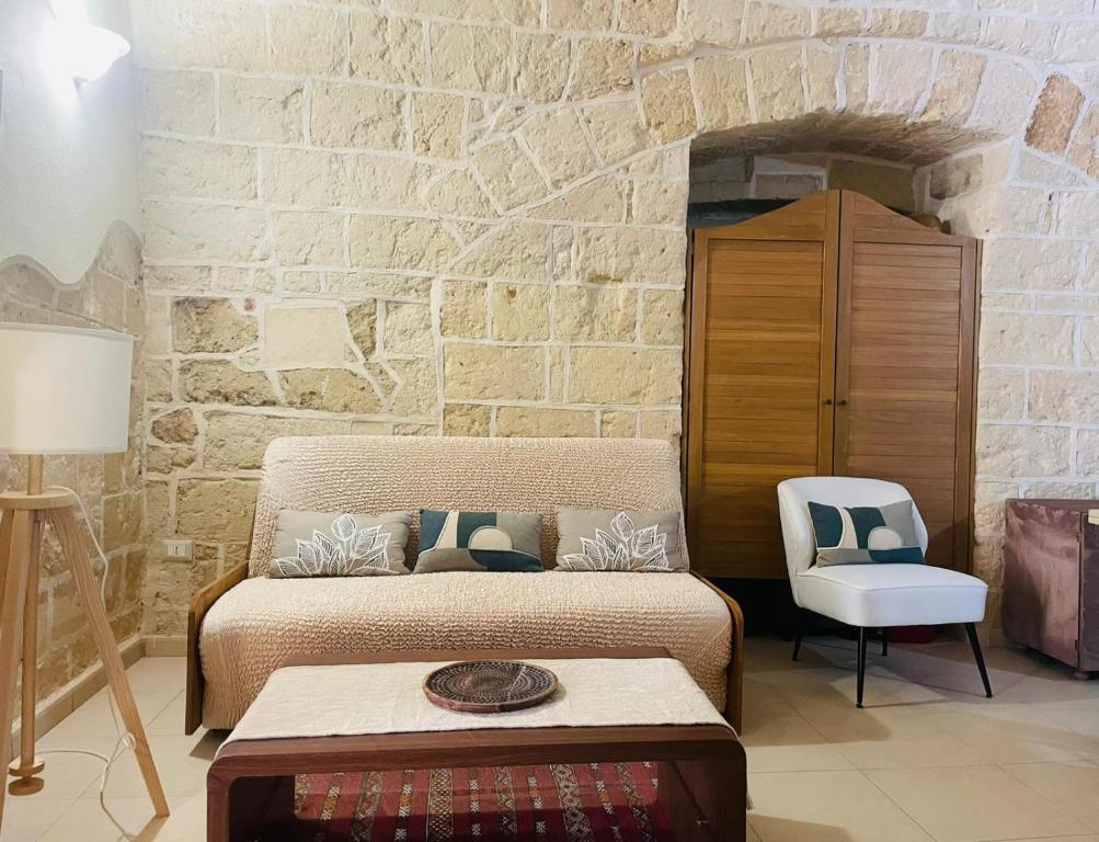 a bedroom with a bed and a stone wall at Casa Vacanze del Angelo Custode in Nardò