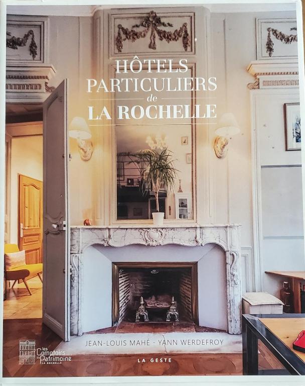 - une cheminée dans le salon avec un panneau au-dessus dans l'établissement Appartement de standing au coeur de la ville, à La Rochelle