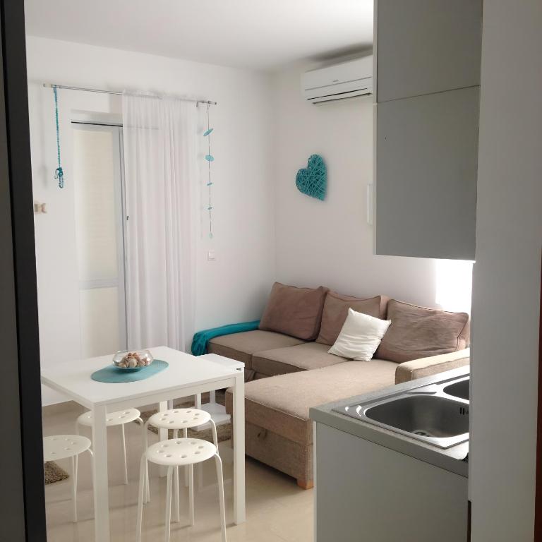 a small living room with a couch and a table at Babe beach Apartment in Novalja