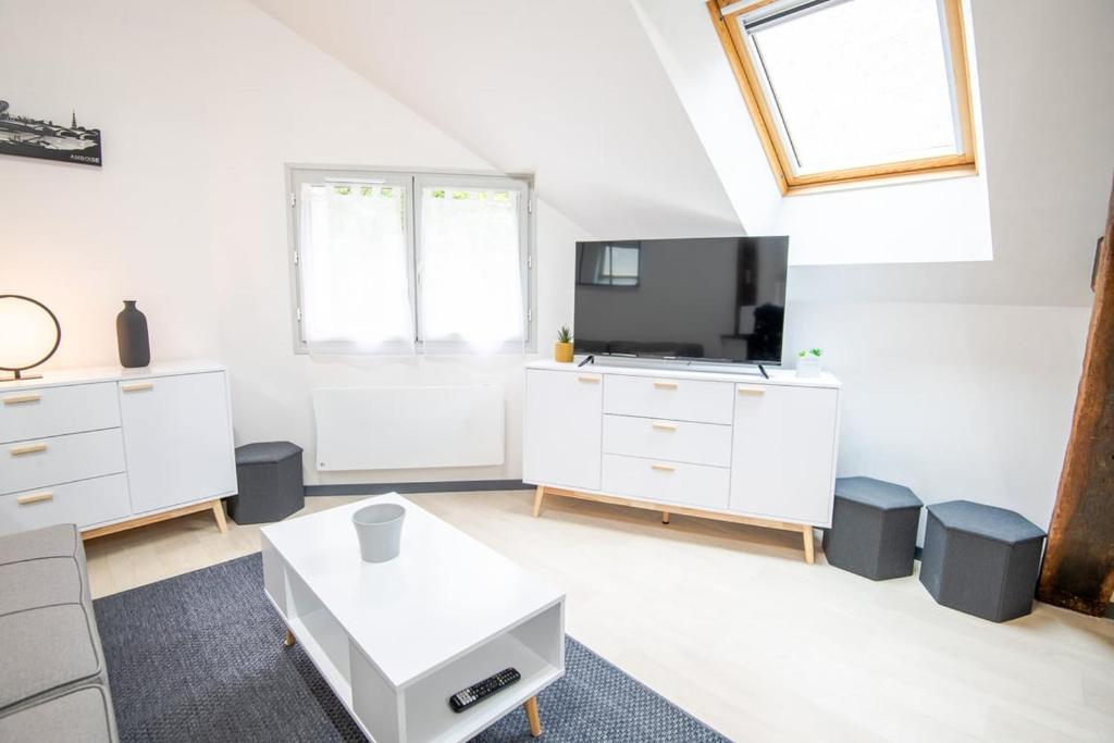 Il comprend un salon doté d'un mobilier blanc et d'une télévision à écran plat. dans l'établissement Au coeur de Newton, à Amboise