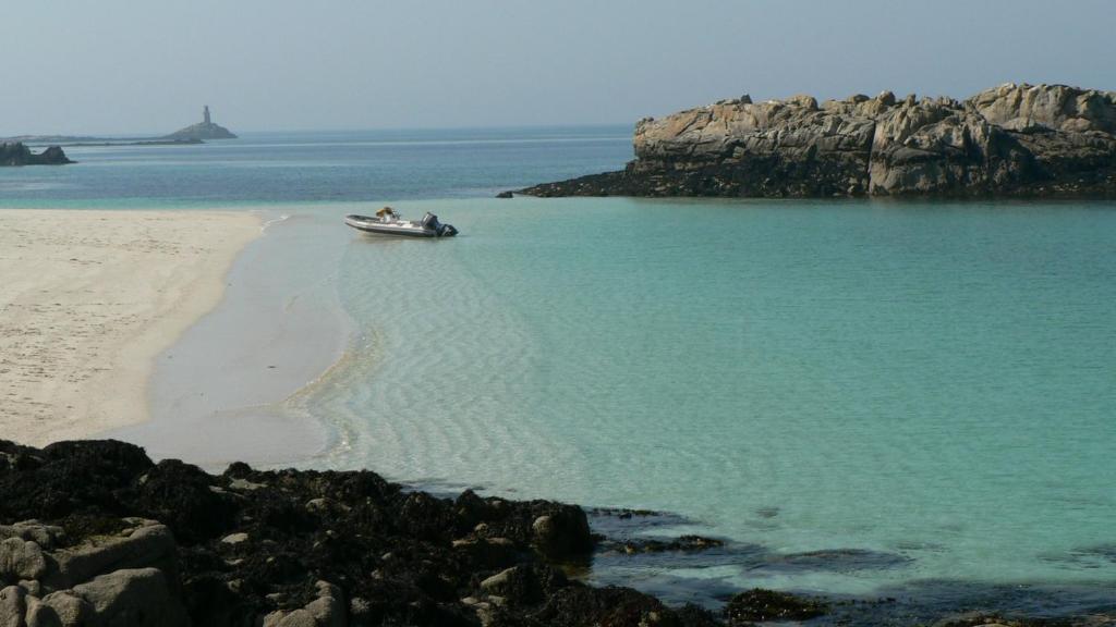 un bateau dans l'eau sur une plage dans l'établissement Lodge Holidays - Glamping Fouesnant, à Fouesnant