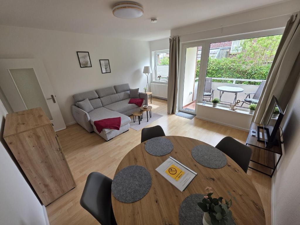 una sala de estar con una mesa y un sofá en FeWo Büsum No 12, en Büsum