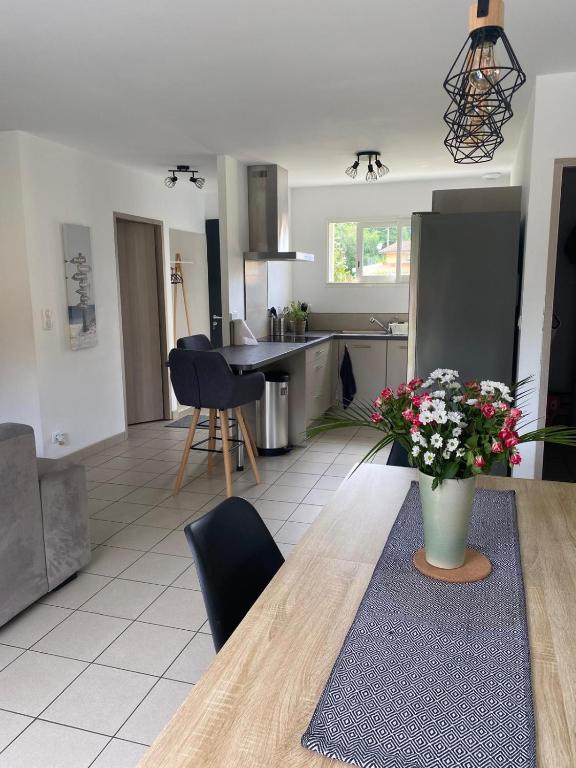 une cuisine avec une table en bois et un vase de fleurs dans l'établissement Maison au calme à 900m du bourg, à Carcans
