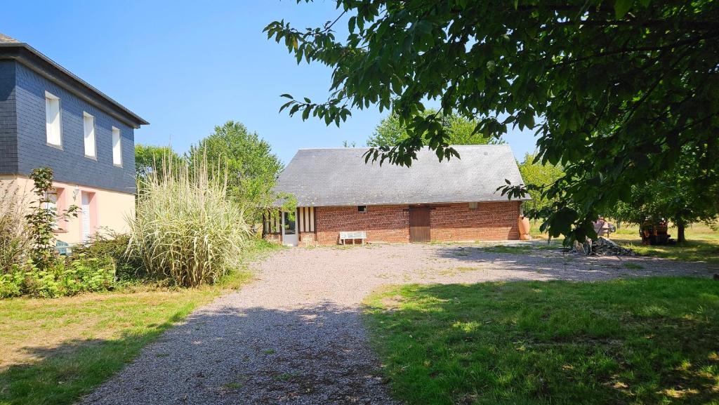 une maison avec une allée en gravier en face d'une maison dans l'établissement maison des champs, à Moyaux
