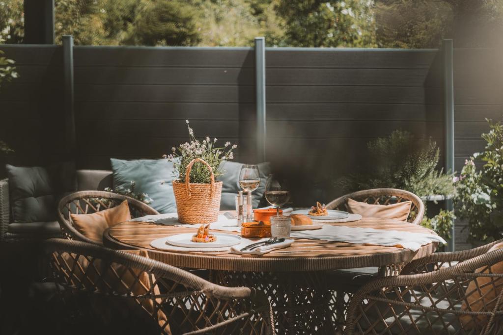 a wooden table with chairs on a patio with a table centerpiece at Boutique Hotel Mandarfnerhof in Sankt Leonhard im Pitztal